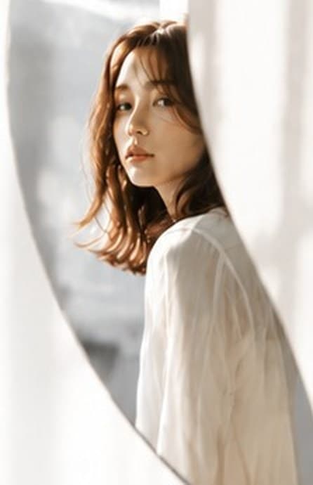 窓辺で振り返る女性