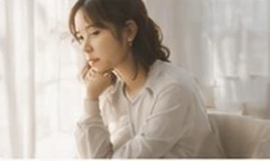 窓辺で頬杖をつく女性